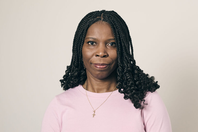 Tase with a serious face, looking directly at the camera, in front of a plain cream background