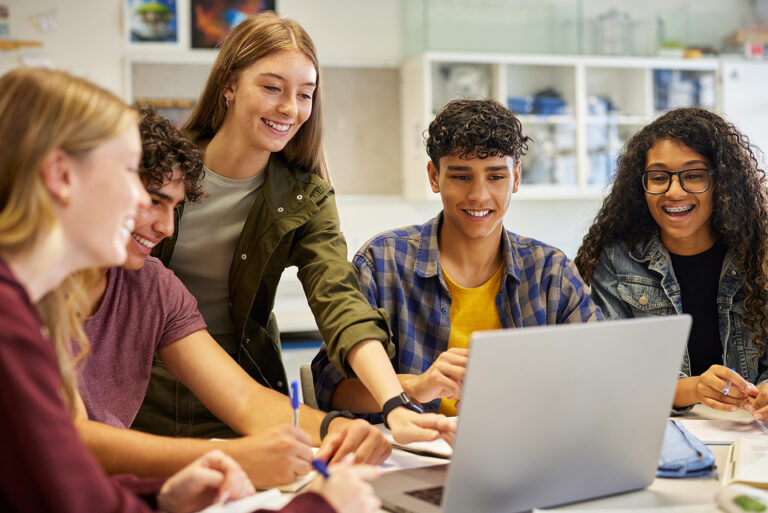 Group of students using laptop during research, working together on a project