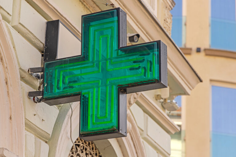 Old Style Neons Tubes Sign Green Cross at Pharmacy Building