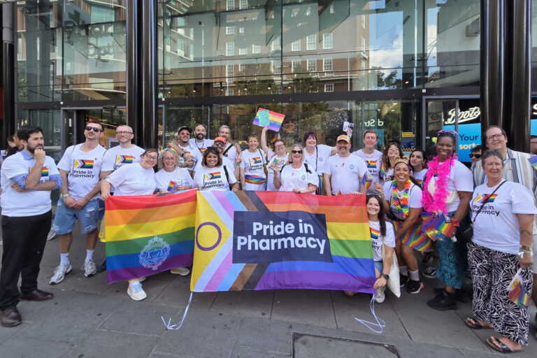 A group of RCPharm workers with pride flags and t shirts stand outside Boots on Oxford Street, London