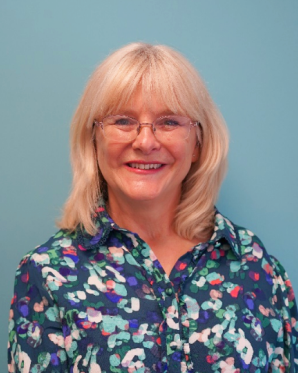 Head and shoulders image of Cath O'Brien, member of the ‘Pharmacy: Delivering a Healthier Wales’ delivery board, wearing a floral shirt