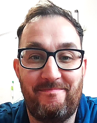 Head and shoulders image of Gareth Tyrrell, member of the ‘Pharmacy: Delivering a Healthier Wales’ delivery board, wearing a blue shirt