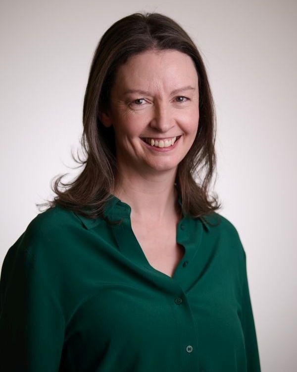 Head and shoulders image of Geraldine McCaffrey, member of the ‘Pharmacy: Delivering a Healthier Wales’ delivery board, wearing a green shirt