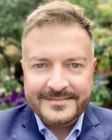 Head and shoulders image of Jonathan Simms, member of the ‘Pharmacy: Delivering a Healthier Wales’ delivery board, wearing a blue shirt and jacket