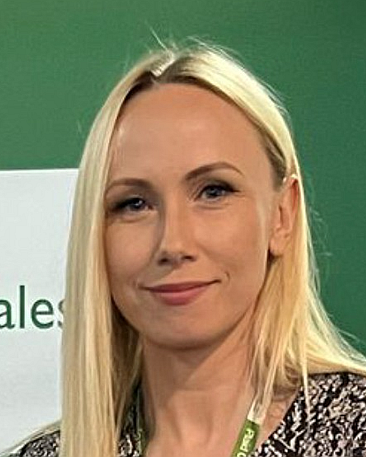 Head and shoulders image of Kayleigh Williams, member of the ‘Pharmacy: Delivering a Healthier Wales’ delivery board, in front of a green background