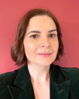 Head and shoulders image of Lia Popa, member of the ‘Pharmacy: Delivering a Healthier Wales’ delivery board, wearing a black jacket