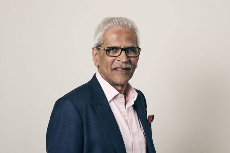 Mahendra Patel in front of a neutral grey background
