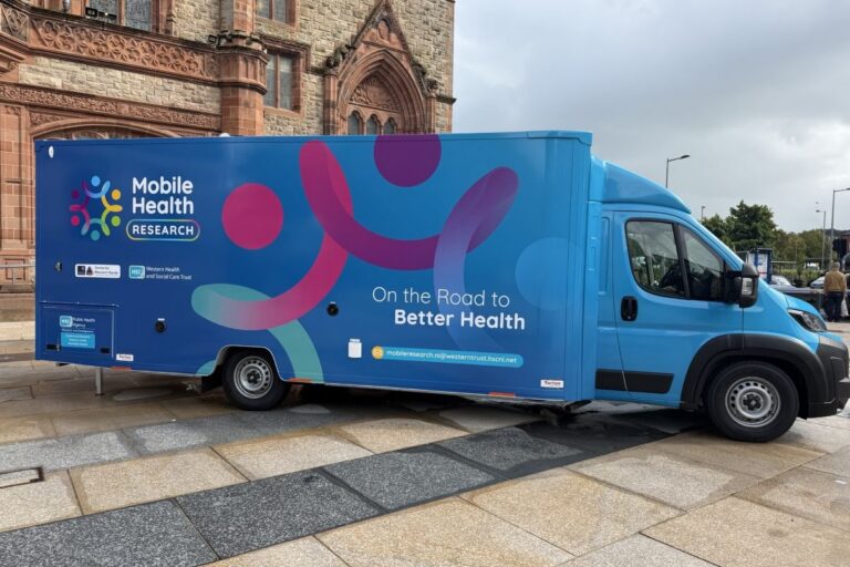 A blue mobile health van with the slogan 'on the road to better health'
