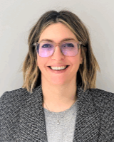 Head and shoulders image of Rhian Carta, member of the ‘Pharmacy: Delivering a Healthier Wales’ delivery board, wearing a grey tee shirt and suit jacket