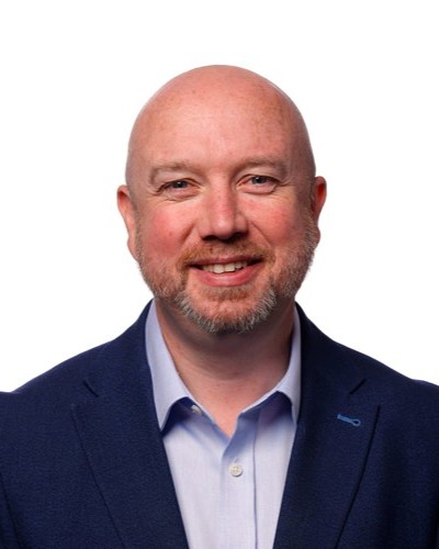Head and shoulders image of Minister Mabon ap Gwynfor wearing a blue shirt and navy suit jacket