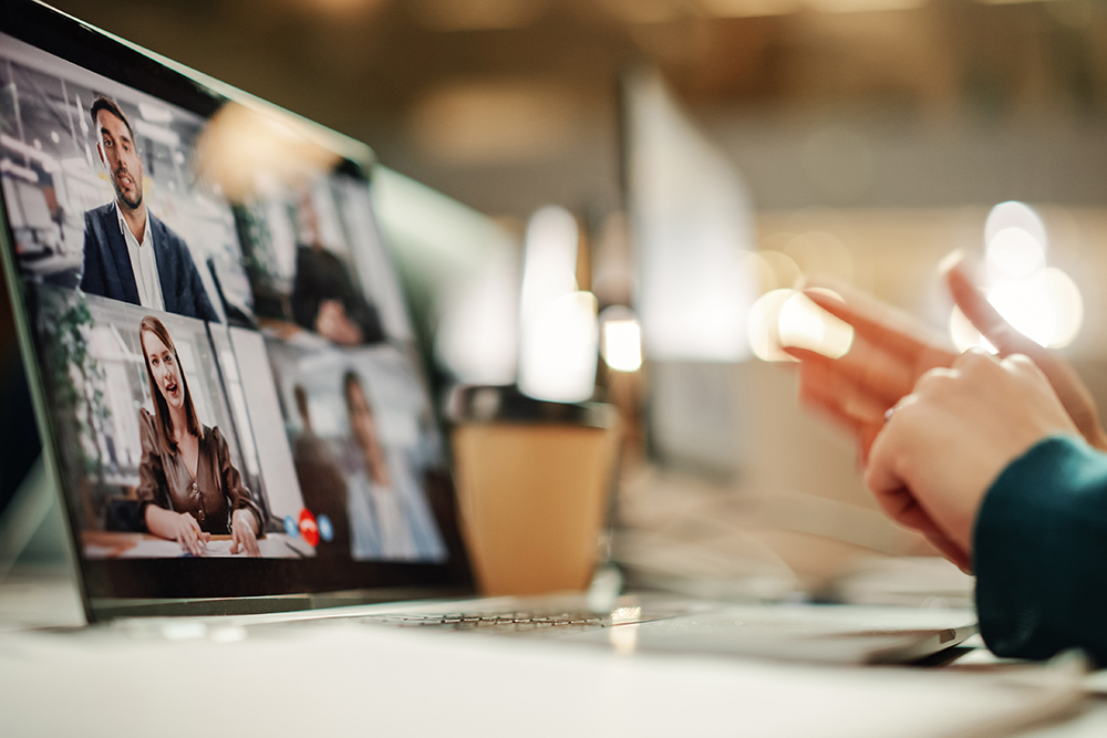 Laptop Screen showing a group call / conference conversation. Person working remotely