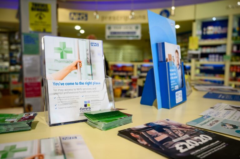 Leaflets and information displays on the counter of a community pharmacy.